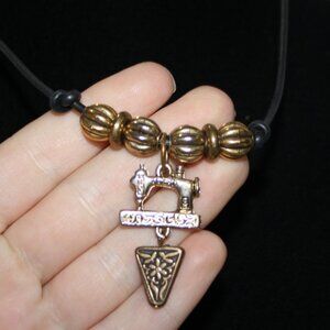 Beautiful black cord and gold sewing machine necklace 18.5"